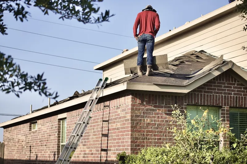Professional roofer working on a residential roof in Colony Ln